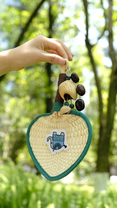 "The Lucky Breeze" - Hand-Woven Heart Palm Fan with Blue Elephant & Seed Charm